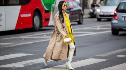 Miki Cheung seen wearing white boots, yellow oversized blazer, beige trench coat, over knees white bag, golden bag, neon sunglasses outside Acne during Paris Fashion Week - Womenswear F/W 2022-2023 on March 02, 2022 in Paris, France.